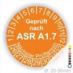 Prüfsiegel für Sicherheits- und Gesundheitsschutz, orangefarbener Kreis mit der Aufschrift "Geprüft nach ASR A1.7", Angaben zum nächsten Prüftermin und Durchmesser von 20-50 mm.