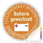 Prüfaufkleber, Prüfplakette rund, Farbe- Orange, Text "Batterie gewechselt" in Weiss. Icon Batterie, Startjahr- 25, Monatszahlen Oben und Jahreszahlen Unten in Kreisform.