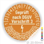 Alt-Text: Prüfplakette gemäß DGUV Vorschrift 3, orangefarbener Kreis mit Angaben zu Prüfterminen und Durchmesser 20-50 mm, zur Sicherheitsüberprüfung von elektrischen Geräten.
