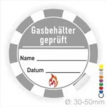 Aufkleber zur Kennzeichnung von geprüften Gasbehältern mit Platz für Name und Datum, Durchmesser 30-50 mm, inklusive Flammensymbol für Sicherheitskennzeichnung.