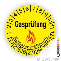 Prüfplaketten, Prüfetiketten rund, Farbe- Gelb, Text "Gasprüfung" in Schwarz danach eine Flamme als Pictogramm oder Icon in Rot, Startjahr- 24, Monatszahlen Oben und Jahreszahlen Unten in Kreisform. Über den Jahreszahlen Text "Nächster Prüftermin"