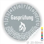 Grau Gasprüfungslabel mit dem Text "Gasprüfung" und "Nächster Prüftermin" Kennzeichnung der nächsten Gasprüfung mit Feuer-Icon und Zahlen von 1 bis 12 Monatszahlen und 26-32 Jahreszahlen. Ideal für die Sicherheit von Gasinstallationen. Durchmesser 20-50 mm.