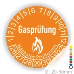 Gasprüfungs-Plakette mit orangefarbenem Design, die den nächsten Prüftermin anzeigt. Durchmesser von 20-50 mm, geeignet für die Kennzeichnung von Gasprüfungen.