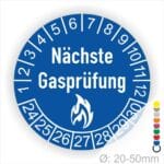 Prüfplaketten rund, Farbe- Blau, Text "Nächste Gasprüfung" in Weiß danach eine Flamme als Pictogramm oder Icon in Weiß, Startjahr- 24, Monatszahlen Oben und Jahreszahlen Unten in Kreisform.