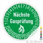 Prüfplaketten rund, Farbe- Grün, Text "Nächste Gasprüfung" in Weiß danach eine Flamme als Pictogramm oder Icon in Weiß, Startjahr- 24, Monatszahlen Oben und Jahreszahlen Unten in Kreisform.