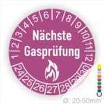 Prüfplaketten rund, Farbe- Lila, Text "Nächste Gasprüfung" in Weiß danach eine Flamme als Pictogramm oder Icon in Weiß, Startjahr- 24, Monatszahlen Oben und Jahreszahlen Unten in Kreisform.