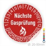 Prüfplaketten rund, Farbe- Rot, Text "Nächste Gasprüfung" in Weiß danach eine Flamme als Pictogramm oder Icon in Weiß, Startjahr- 24, Monatszahlen Oben und Jahreszahlen Unten in Kreisform.