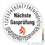 Prüfplaketten rund, Farbe- Weiß, Text "Nächste Gasprüfung" in Schwarz danach eine Flamme als Pictogramm oder Icon in Rot, Startjahr- 24, Monatszahlen Oben und Jahreszahlen Unten in Kreisform.