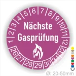 Runder Aufkleber in Lila zur Kennzeichnung der nächsten Gasprüfung mit Feuer-Icon und Zahlen von 1 bis 12 Monatszahlen und 26-32 Jahreszahlen. Ideal für die Sicherheit von Gasinstallationen. Durchmesser 20-50 mm.