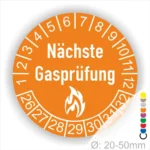 Runder Aufkleber in Orange zur Kennzeichnung der nächsten Gasprüfung mit Feuer-Icon und Zahlen von 1 bis 12 Monatszahlen und 26-32 Jahreszahlen. Ideal für die Sicherheit von Gasinstallationen. Durchmesser 20-50 mm.