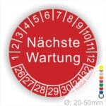 Prüfplaketten, Prüfetiketten rund, Farbe- Rot, Text "Nächste Wartung" in Weiß. Startjahr- 26, Monatszahlen Oben und Jahreszahlen Unten in Kreisform.