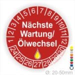 Prüfetiketten, Prüfaukleber rund, Farbe- Rot, Text "Nächste Wartung/Ölwechsel" in Weiß. Startjahr- 24, Monatszahlen Oben und Jahreszahlen Unten in Kreisform, über den Jahreszahlen ein Öltropfen als Icon/Piktogramm in Gelb.