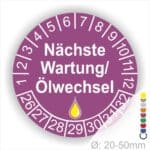Prüfetiketten, Prüfaukleber rund, Farbe- Lila, Text "Nächste Wartung/Ölwechsel" in Weiß. Startjahr- 26, Monatszahlen Oben und Jahreszahlen Unten in Kreisform, über den Jahreszahlen ein Öltropfen als Icon/Piktogramm in Gelb.