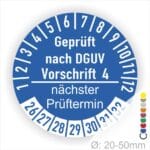 Prüfplakette mit Text Geprüft nach Dguv Vorschrift 4 und Nächster Prüftermin mit zwischen Strich in Weiss. Plaketten Farbe- Blau und Text in Weiss. Monatszahlen oben und Jahreszahlen unten beginnend mit Startjahr- 26