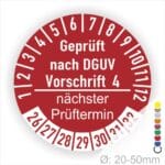 Prüfplakette mit Text Geprüft nach Dguv Vorschrift 4 und Nächster Prüftermin mit zwischen Strich in Weiss. Plaketten Farbe- Rot und Text in Weiss. Monatszahlen oben und Jahreszahlen unten beginnend mit Startjahr- 26