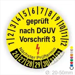 Prüfplakette rund mit Text geprüft nach DGUV Vorschrift 3 und Nächster Prüftermin mit Elektropfeil in rot. Plaketten Farbe- gelb und Text in schwarz. Monatszahlen oben und Jahreszahlen unten beginnend mit Startjahr- 2026