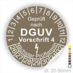 Prüfplakette rund mit Text geprüft nach Dguv Vorschrift 3 danach Elektropfeilund Text Nächster Prüftermin. Plaketten Farbe- Braun und Text in Weiß. Monatszahlen oben und Jahreszahlen unten beginnend mit Startjahr- 26.