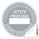 Prüfplaketten, rund, Farbe- Grau, Text "LETZTE PRÜFUNG" in Weiß. Als nächstes kommt ein Beschriftungfeld / Leerfeld in Farbe Weiß. Startjahr- 25, Monatszahlen Oben und Jahreszahlen Unten in Kreisform in Weiß.