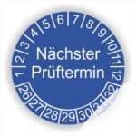 Prüfplakette mit Text Nächster Prüftermin Startjahr- 26, Monatszahlen Oben und Jahreszahlen Unten in Kreisform. Farbe Blau