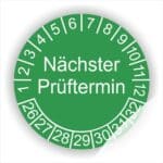 Prüfsiegel Prüfplakette mit Text Nächster Prüftermin Startjahr- 26, Monatszahlen Oben und Jahreszahlen Unten in Kreisform. Farbe Gruen