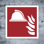 Symbol für Feuerwehr mit Helm und Flammen auf rotem Hintergrund, geeignet für Brandschutz- und Sicherheitsanwendungen.