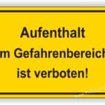 Warnschild mit der Aufschrift "Aufenthalt im Gefahrenbereich ist verboten" auf gelbem Hintergrund.