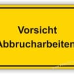 Warnschild in Gelb mit der Aufschrift "Vorsicht Abbrucharbeiten!" zur Kennzeichnung von Gefahrenbereichen auf Baustellen.