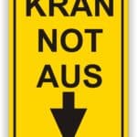 Sicherheitswarnschild für Kran mit der Aufschrift "Kran Not Aus" und einem nach unten zeigenden Pfeil, um auf die Notabschaltung hinzuweisen.
