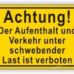 Warnschild mit der Aufschrift "Achtung! Der Aufenthalt und Verkehr unter schwebender Last ist verboten." in gelber und schwarzer Schrift.