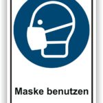 Hinweiszeichen zur Maskenpflicht mit Symbol eines Kopfes, der eine Maske trägt, und dem Text "Maske benutzen".