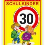 Schild mit der Aufschrift "Achtung Schulkindern" und der Geschwindigkeitsbegrenzung von 30 km/h, zeigt zwei Kinder mit Schulranzen auf dem Weg zur Schule.