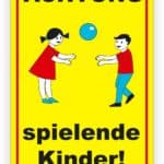 Schild mit der Aufschrift "Achtung! spielende Kinder!" in gelber Farbe, das zwei Kinder zeigt, die mit einem Ball spielen.