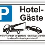 Parkplatzschild für Hotelgäste mit Hinweis auf Abschleppdienst für falsch parkende Fahrzeuge.