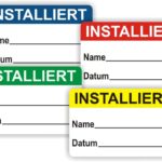 Bunte Installationsetiketten mit Platz für Name und Datum, in den Farben Blau, Rot, Grün und Gelb, beschriftet mit "INSTALLIERT". Ideal für die Kennzeichnung von installierten Geräten oder Systemen.