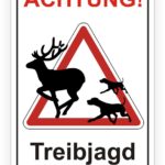 Warnschild für Treibjagd mit silhouette eines Rehs und Jagdhunden, Hinweis auf erhöhte Vorsicht für Fußgänger und Autofahrer.