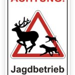 Achtungsschild für Jagdbetrieb mit Silhouetten eines Rehs und jagenden Hunden, warnt vor Wildwechsel und Jagdaktivitäten.