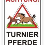 Achtungsschild für Turnierpferde mit zwei Pferden, einem Fohlen und einem erwachsenen Pferd, die auf einer Wiese laufen. Das Schild warnt vor der Nähe von Pferden und ist deutlich mit "Achtung!" und "Turnierpferde" beschriftet.