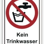 Schild mit der Aufschrift "Kein Trinkwasser" und einem durchgestrichenen Wasserhahn über einem Glas, das auf die Unzulässigkeit von Trinkwasser hinweist.