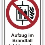 Sicherheitsschild, das besagt: "Aufzug im Brandfall nicht benutzen", mit einem Symbol für einen Aufzug und einem Flammensymbol.