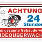 Warnschild mit einer Überwachungskamera, das auf die 24-stündige Videoüberwachung des gesamten Gebäudes hinweist.
