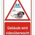 Schild zur Videoüberwachung eines Gebäudes mit Hinweis auf 24-Stunden-Überwachung.