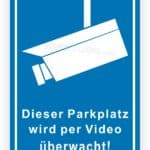 Schild zur Videoüberwachung eines Parkplatzes mit Kamera-Symbol und dem Hinweis auf die Überwachung.