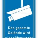 Sicherheitszeichen für Videoüberwachung auf einem Gelände mit Kamera-Symbol und dem Hinweis, dass das gesamte Gebiet überwacht wird.