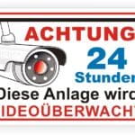 Sicherheitswarnschild mit Kamera-Illustration, das auf 24-Stunden-Videoüberwachung hinweist.