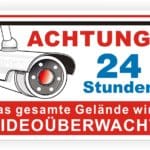 Sicherheitswarnschild mit einer Überwachungskamera, das auf die 24-stündige Videoüberwachung des gesamten Geländes hinweist.