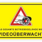 Schild mit der Aufschrift „Das gesamte Betriebsgebiet wird videoüberwacht“ und einem Symbol einer Überwachungskamera auf gelbem Hintergrund.