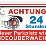 Achtungsschild für einen überwachten Parkplatz mit Kamera, Hinweis auf 24-Stunden-Videobeobachtung.