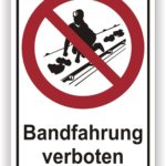 Schild mit der Aufschrift "Bandfahrt verboten" und einem Symbol, das einen Skifahrer zeigt, der durch ein rotes Verbotssymbol gekennzeichnet ist.