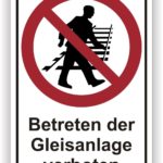 Schild mit dem Hinweis "Betreten der Gleisanlage verboten" und einem Symbol, das eine Person zeigt, die sich in einem verbotenen Bereich bewegt.