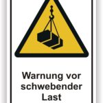 Warnschild mit der Aufschrift "Warnung vor schwebender Last" in gelber Dreiecksform, das auf Gefahren durch hängende Lasten hinweist.